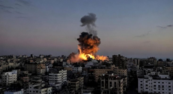 massive explosion engulfs Gaza City buildings at dusk during Israeli airstrike